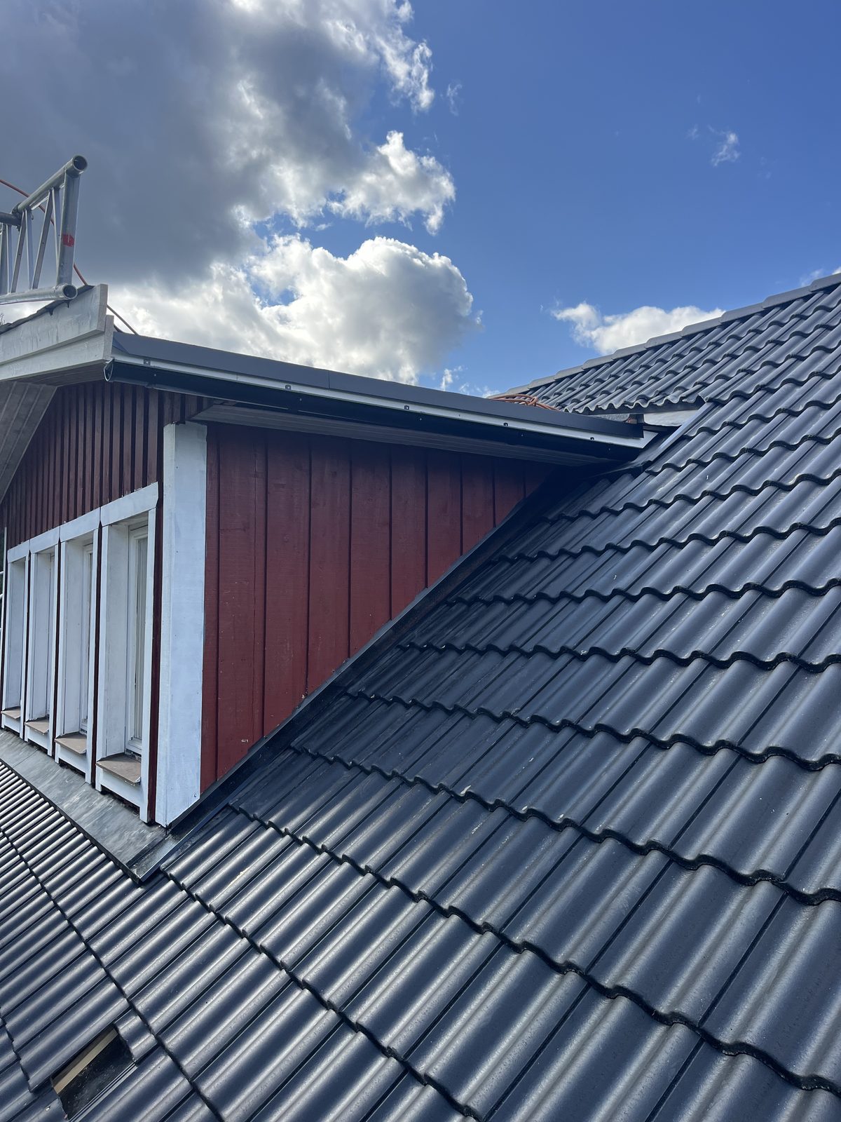 Färdig anslutning mellan svart tegeltak och huskropp